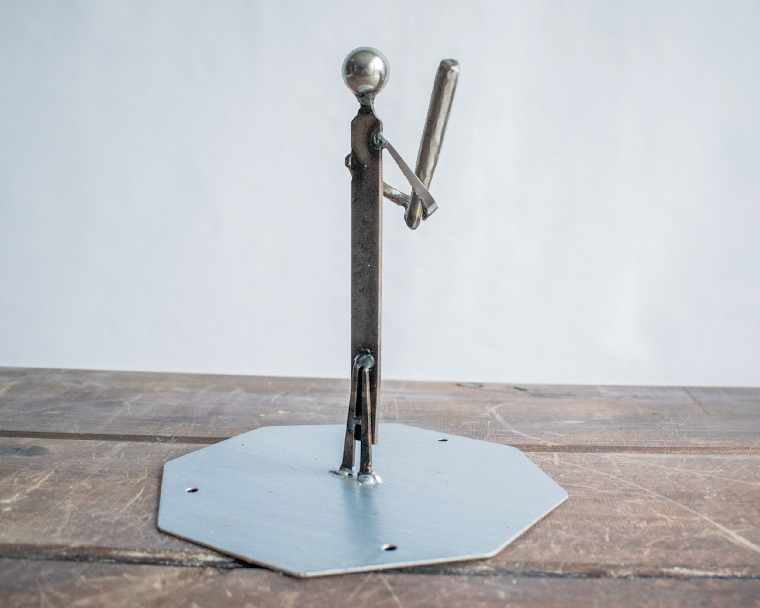 Rear view of welded metal baseball player sculpture highlighting clean lines, raw steel surfaces, and handmade construction.