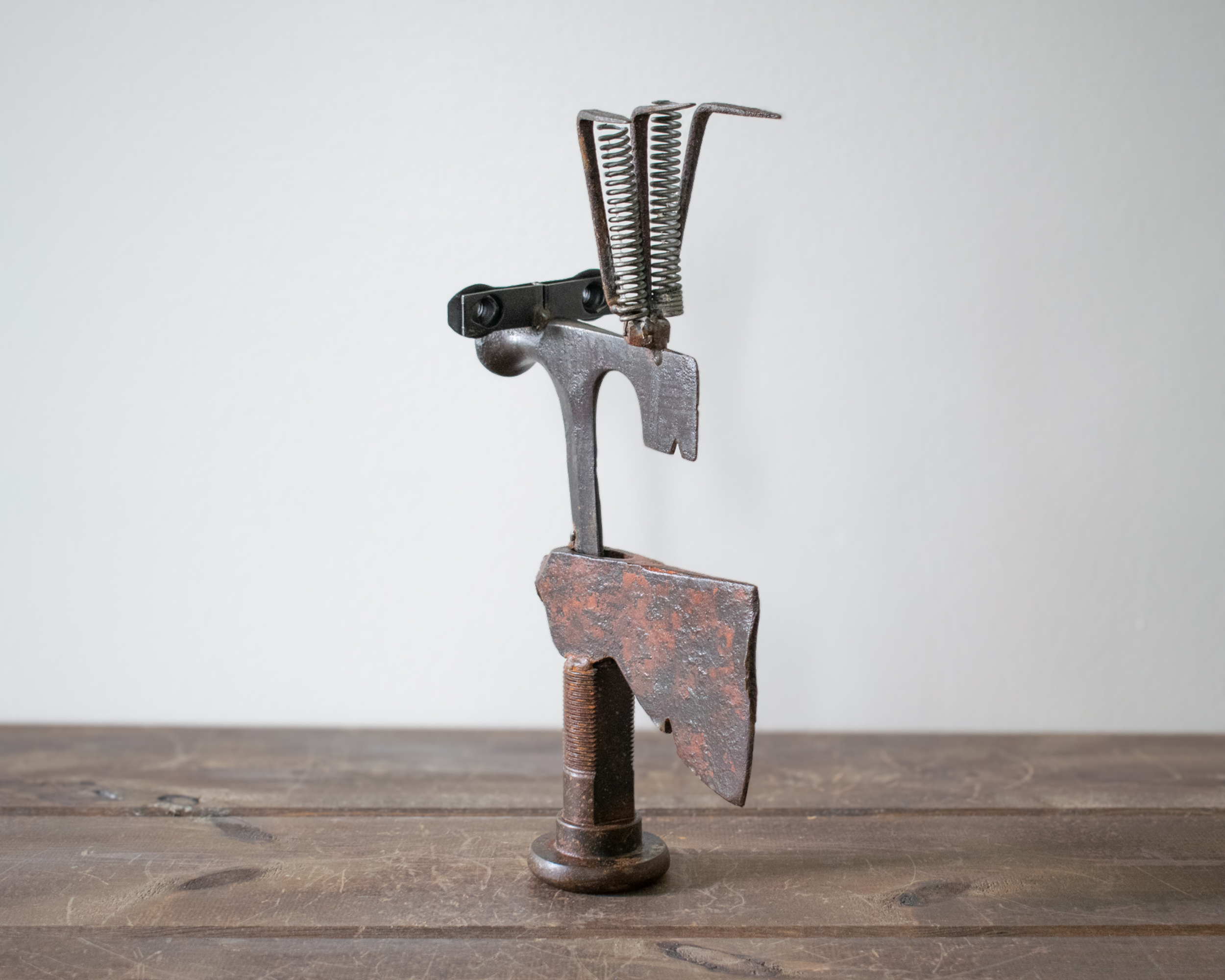 Side view of Mr. Hatchet industrial metal sculpture featuring a hatchet head torso and welded steel components.