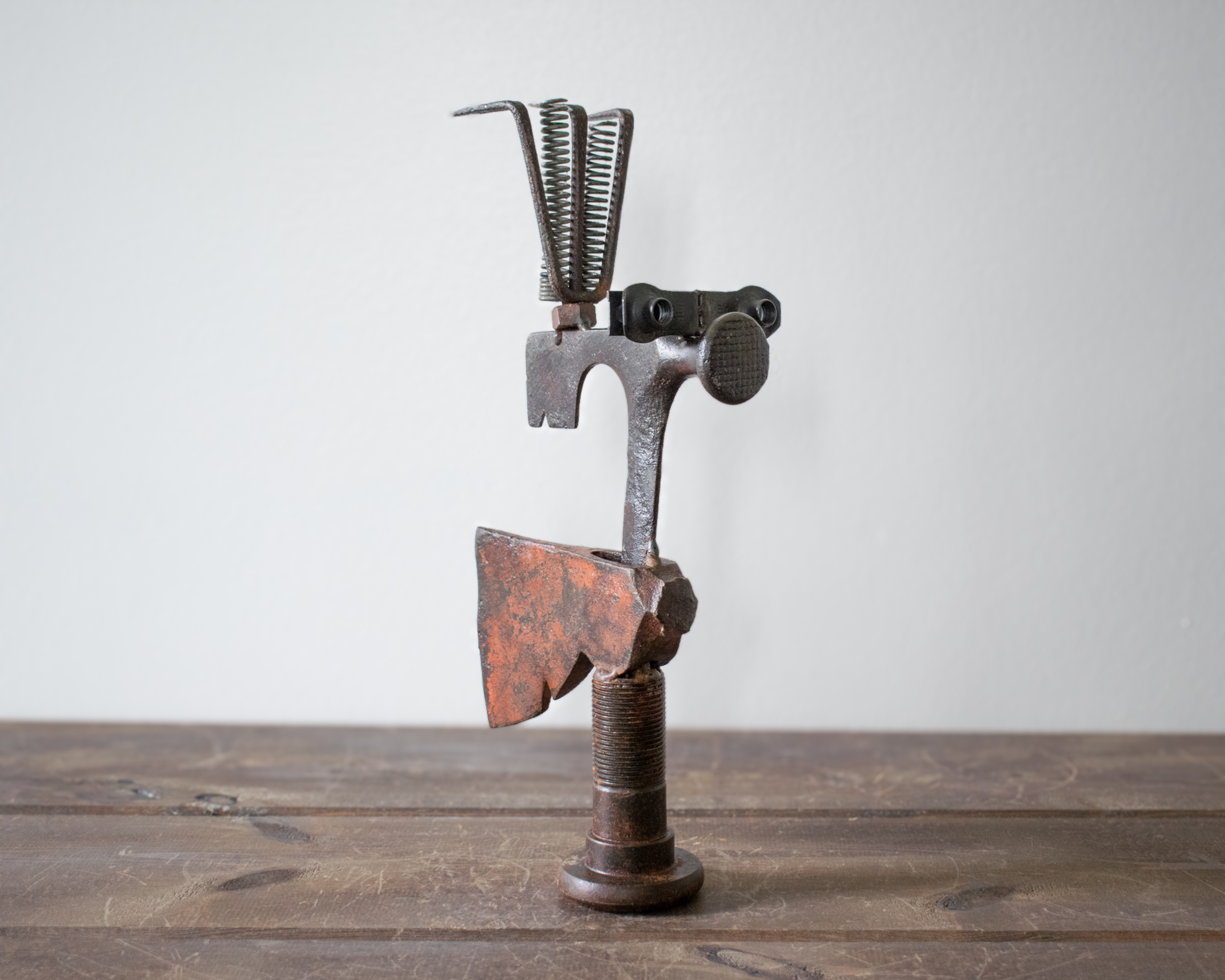 Three-quarter angle of Mr. Hatchet sculpture highlighting balance, character, and industrial metal construction.