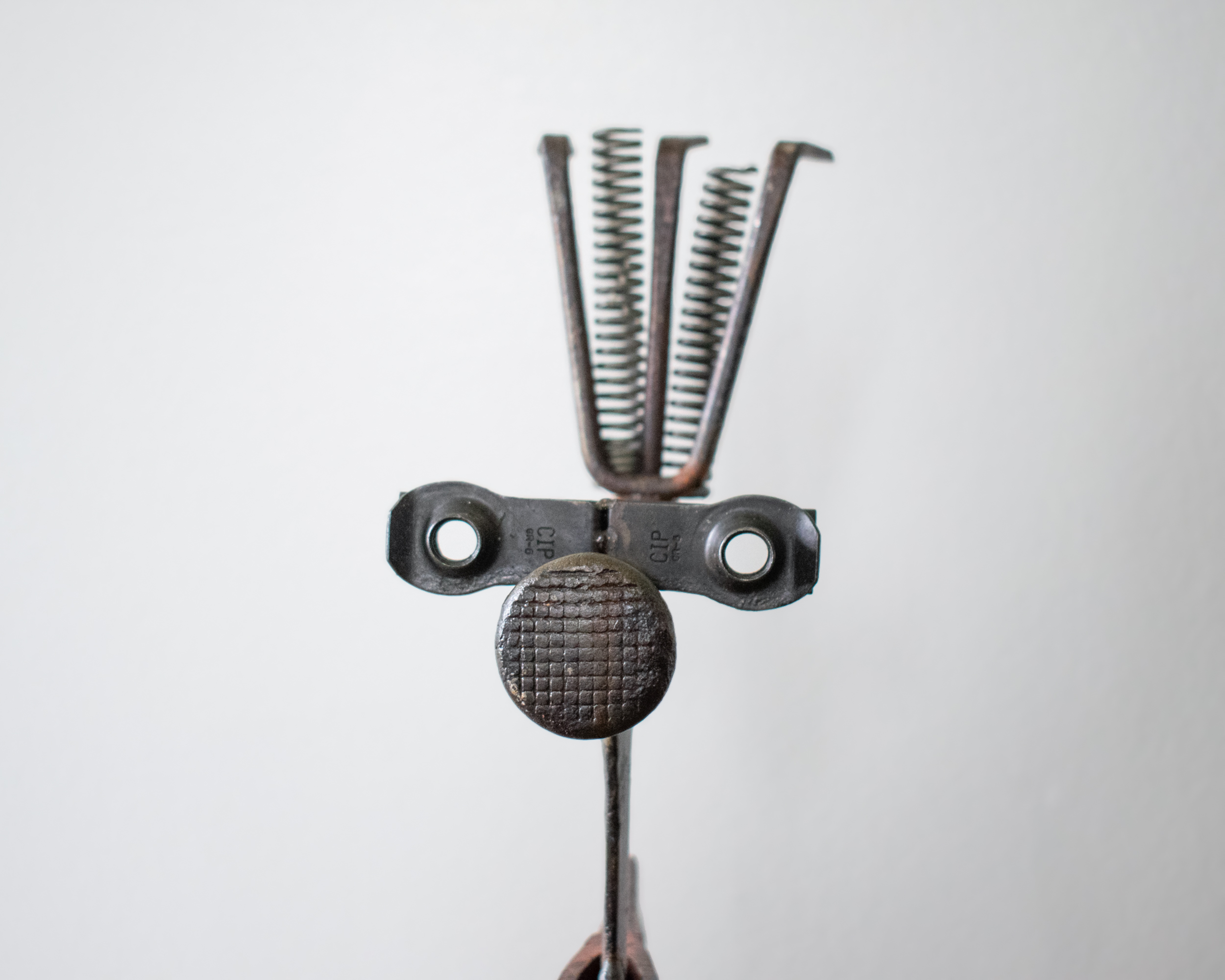 Front-facing close-up of Mr. Hatchet industrial metal sculpture emphasizing expressive character and raw materials.