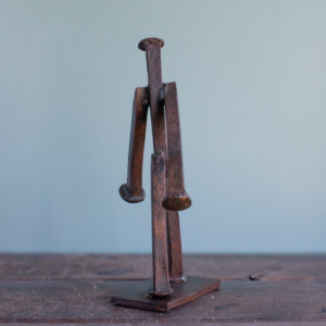 Rear view of welded railroad spike walking figure sculpture made from reclaimed steel spikes