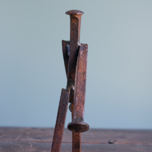 Close view of welded railroad spike sculpture body showing industrial steel texture and form