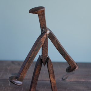 Front angled view of welded railroad spike walking figure sculpture tabletop display