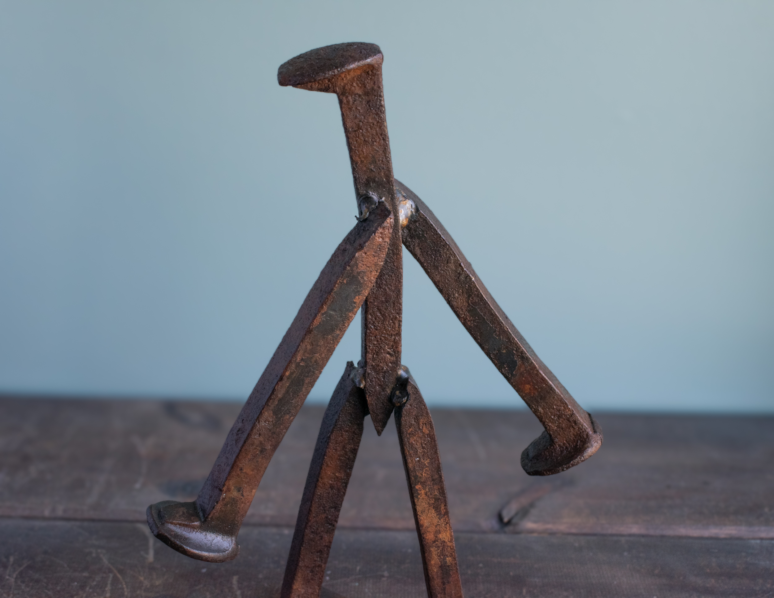 Front angled view of welded railroad spike walking figure sculpture tabletop display