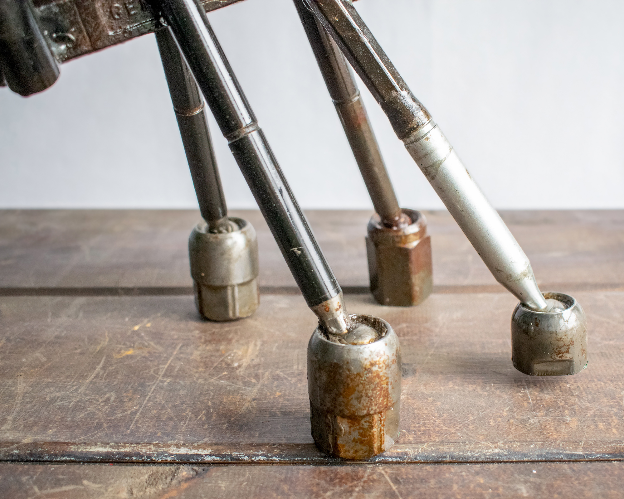 Close-up of reclaimed metal legs and textured steel feet on industrial garden art.