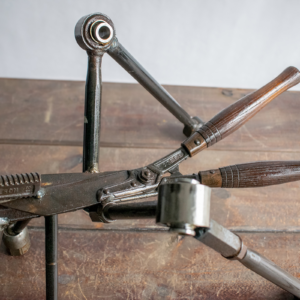 Close-up of wooden handle and car control arm details on a reclaimed metal insect sculpture.
