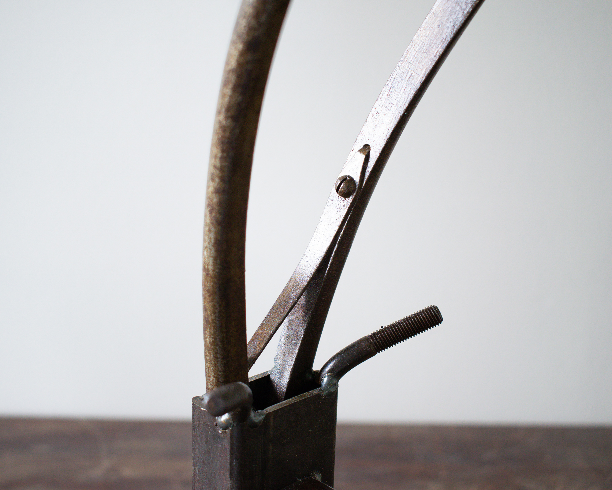Close-up rear view of reclaimed steel horns and welded hardware on industrial animal art sculpture.