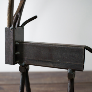 Side detail of rectangular steel tubing body and welded tail on a metal wildlife sculpture.