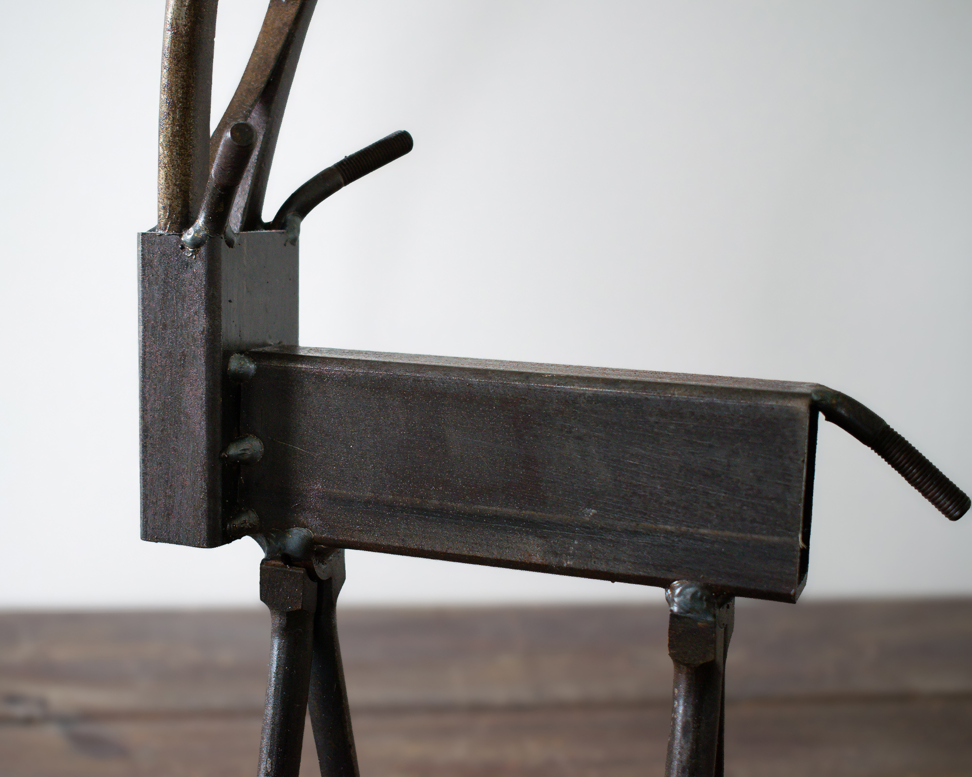 Side detail of rectangular steel tubing body and welded tail on a metal wildlife sculpture.