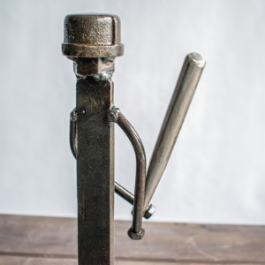 Close-up of baseball player sculpture with ball bearing head and welded metal bat detail.