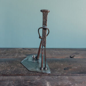 Back view of welded metal golfer sculpture on a raw steel base with a ball bearing golf ball.
