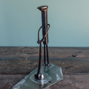 Angled view of welded metal golfer sculpture made from reclaimed steel with a simple swing pose.