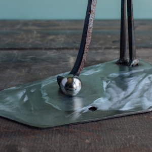 Close-up of ball bearing golf ball and steel base on a welded metal golfer sculpture.