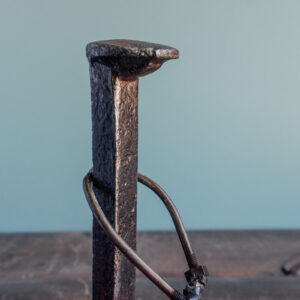 Close-up of railroad spike body and raw steel texture on handmade industrial golf decor.