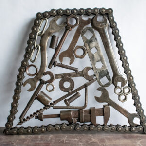 Industrial metal wall art made from motorcycle chain, reclaimed wrenches, nuts, bolts, and steel hardware.