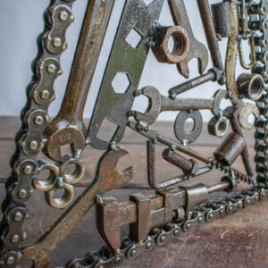 Back view, angled close-up of reclaimed steel hardware and wrenches in a welded tool sculpture.