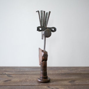Welded metal hatchet sculpture made from reclaimed steel, old tools, springs, and a large bolt base.