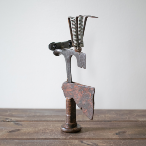 Side view of Mr. Hatchet, an industrial metal sculpture made from axe heads, springs, and scrap steel.