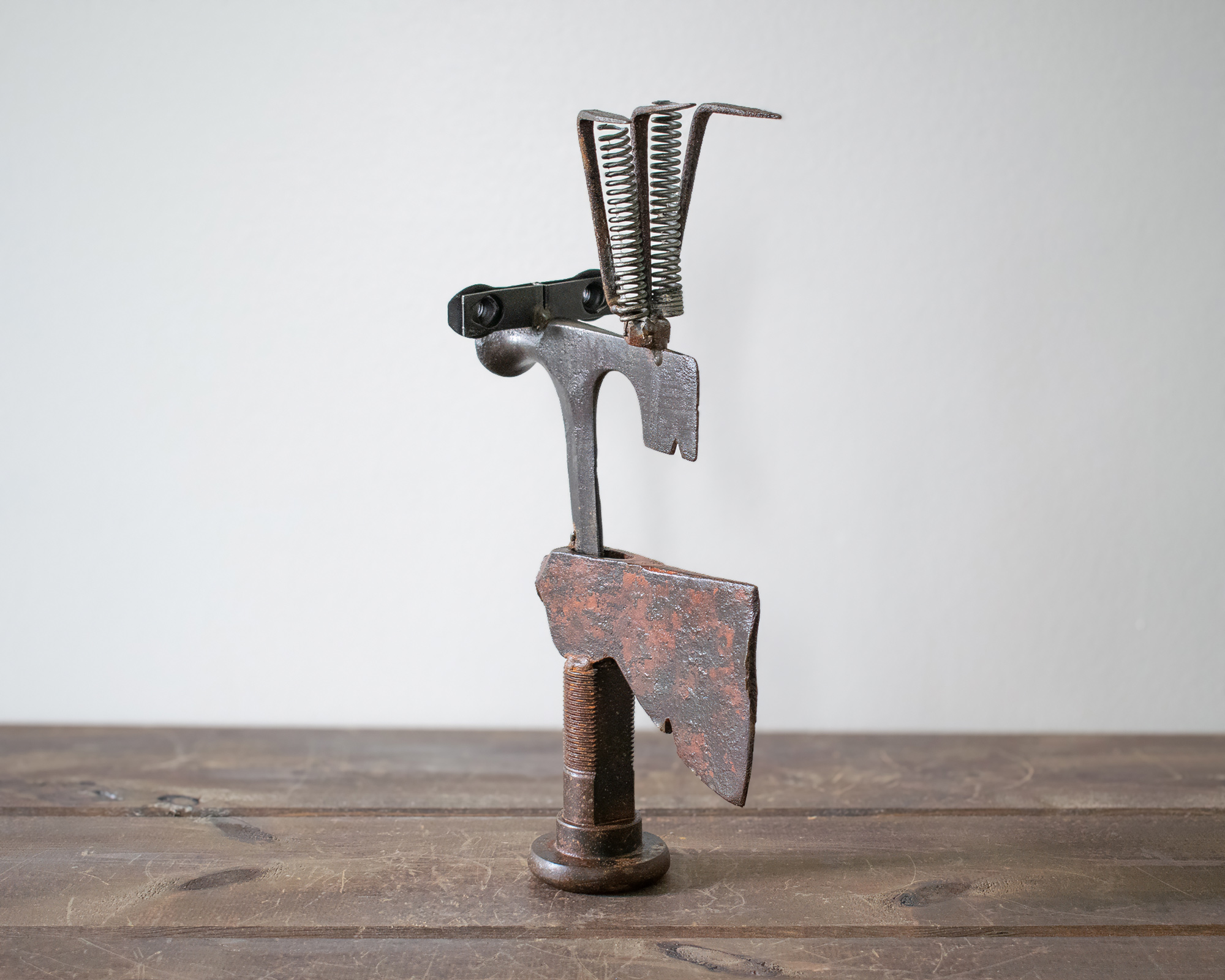 Side view of Mr. Hatchet, an industrial metal sculpture made from axe heads, springs, and scrap steel.